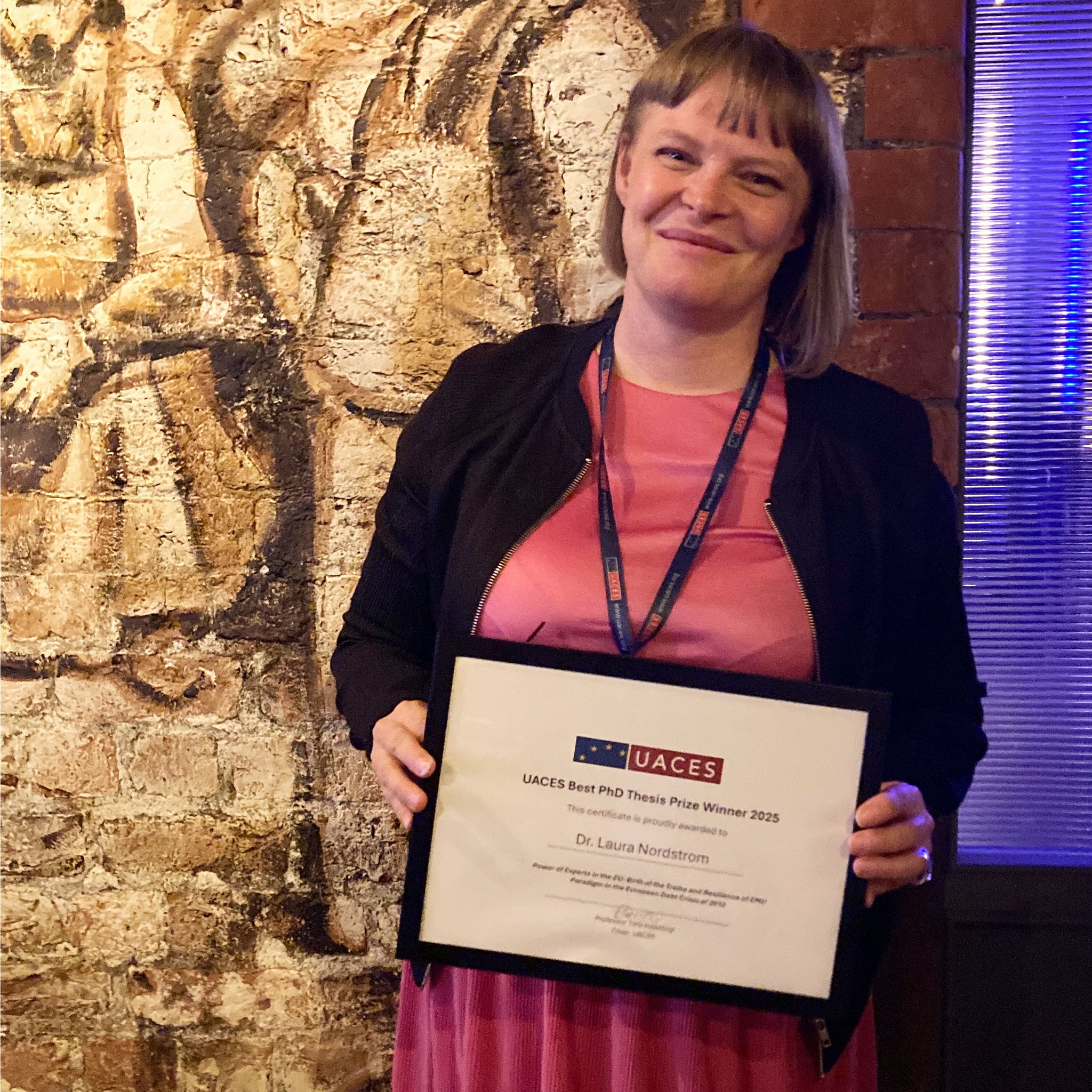 Scholar Laura Nordström holding her framed prize